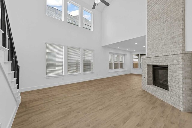 unfurnished living room with light hardwood / wood-style flooring, a fireplace, and ceiling fan