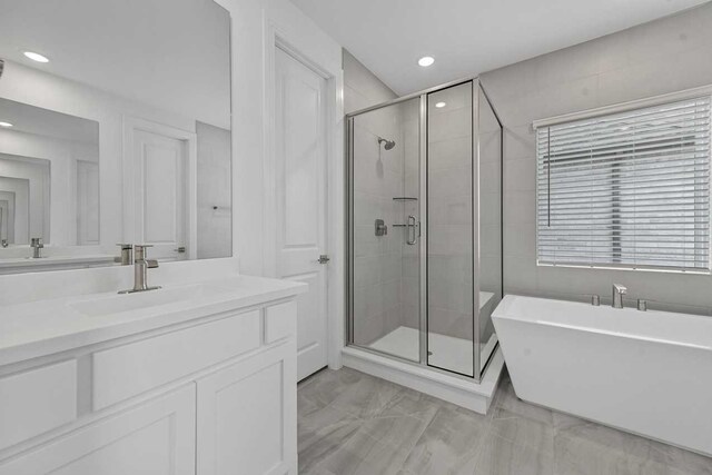 bathroom featuring vanity and separate shower and tub