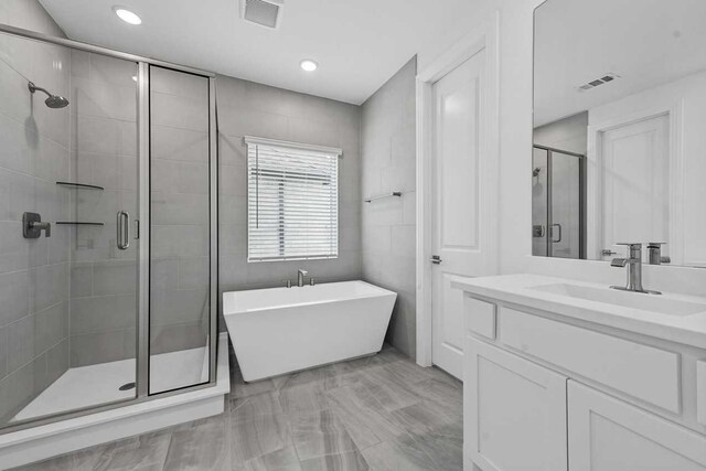 bathroom featuring vanity and shower with separate bathtub