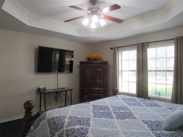 bedroom featuring ceiling fan, multiple windows, ornamental molding, and a raised ceiling