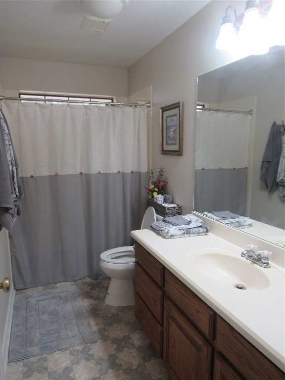 bathroom featuring vanity, tile floors, and toilet