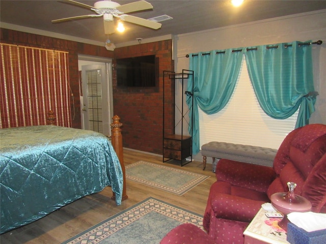 bedroom featuring ceiling fan, ornamental molding, and hardwood / wood-style flooring