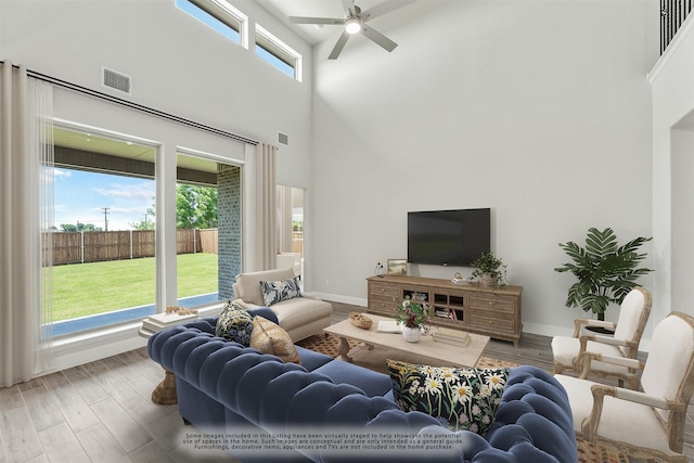 living room with ceiling fan, a high ceiling, and hardwood / wood-style flooring