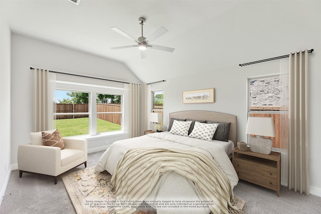 bedroom with ceiling fan, vaulted ceiling, carpet floors, and multiple windows