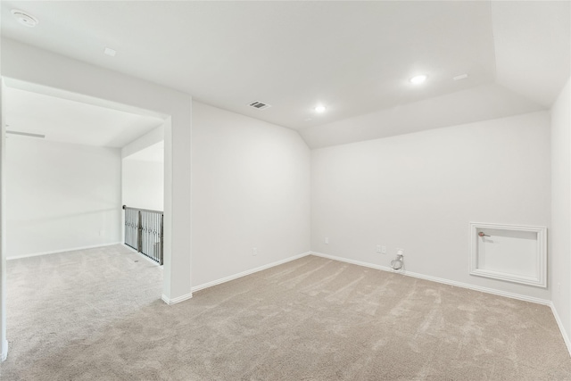 unfurnished room featuring light colored carpet and lofted ceiling