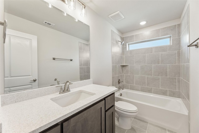 full bathroom featuring tile patterned flooring, vanity, tiled shower / bath combo, and toilet