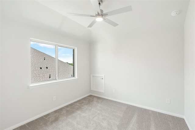 carpeted spare room with ceiling fan and vaulted ceiling