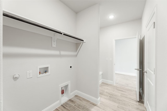 clothes washing area with hookup for an electric dryer, washer hookup, light hardwood / wood-style flooring, and gas dryer hookup