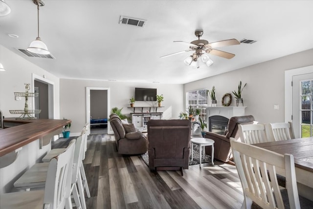 living room with ceiling fan and dark wood-type flooring