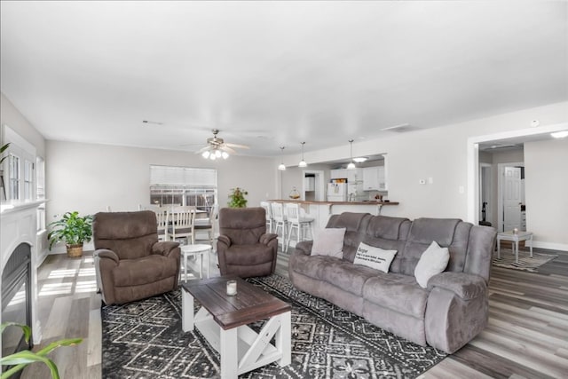 living room featuring dark hardwood / wood-style floors and ceiling fan