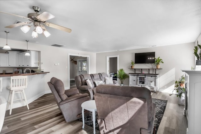 living room featuring ceiling fan and wood-type flooring