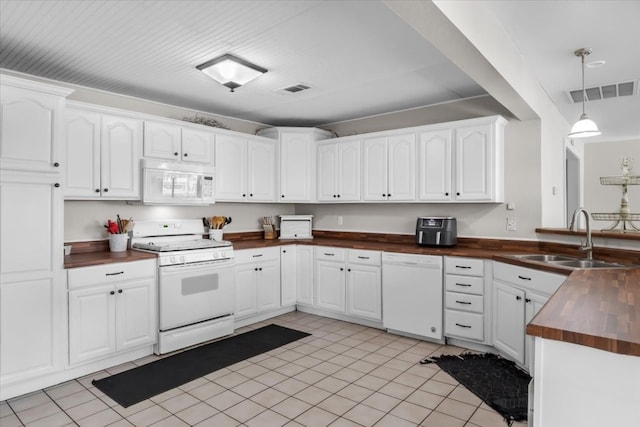 kitchen with white cabinetry, light tile floors, sink, white appliances, and hanging light fixtures