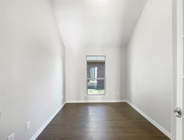 unfurnished room with vaulted ceiling and dark hardwood / wood-style flooring