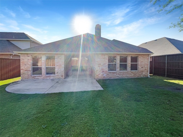 back of property with a yard and a patio area