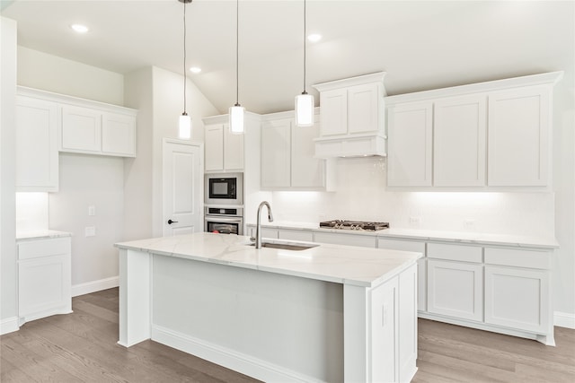 kitchen featuring pendant lighting, a kitchen island with sink, sink, white cabinetry, and stainless steel appliances