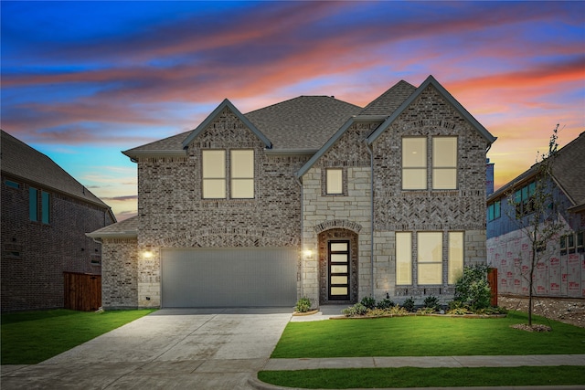 view of front of house featuring a garage and a lawn