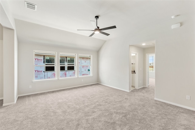 carpeted spare room featuring ceiling fan, a healthy amount of sunlight, and vaulted ceiling