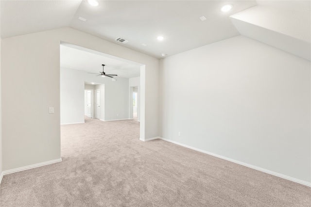 spare room featuring ceiling fan, light colored carpet, and vaulted ceiling