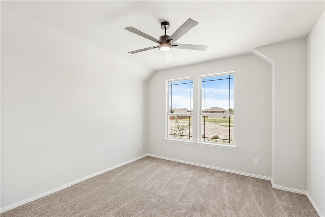 empty room featuring ceiling fan, light colored carpet, and vaulted ceiling