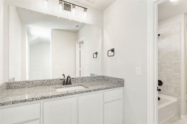 bathroom with vanity and tiled shower / bath