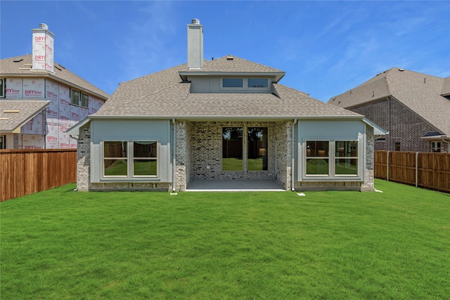 rear view of house with a yard and a patio