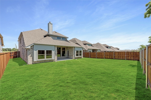 rear view of property featuring a lawn