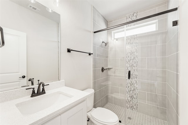 bathroom with vanity, a shower with shower door, and toilet