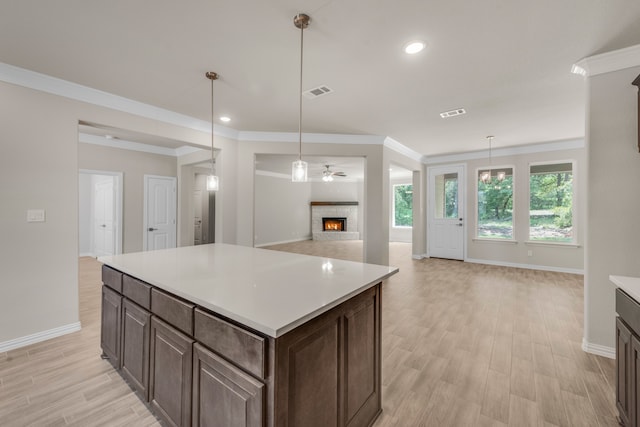 kitchen featuring dark brown cabinetry, ceiling fan, light hardwood / wood-style floors, and decorative light fixtures