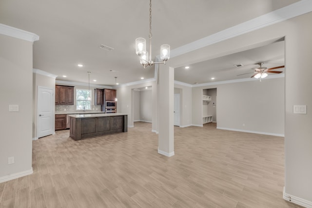 kitchen featuring backsplash, ceiling fan with notable chandelier, light hardwood / wood-style flooring, and a kitchen island