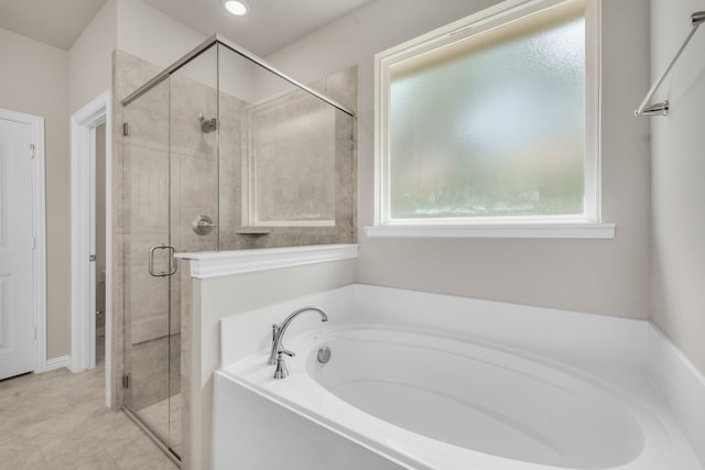 bathroom with independent shower and bath and tile patterned floors