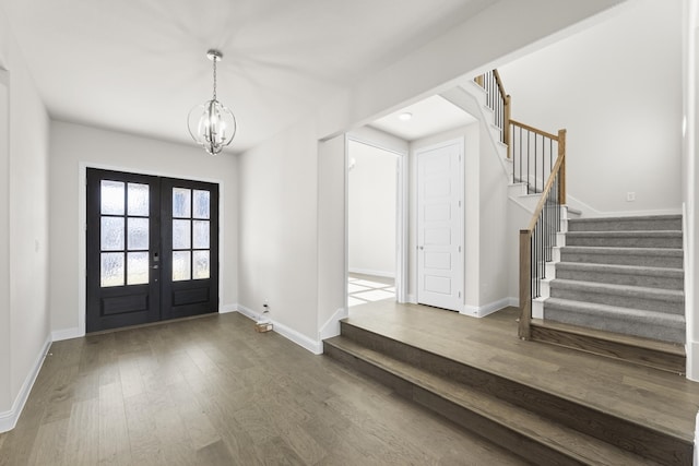 entryway featuring french doors, an inviting chandelier, and hardwood / wood-style flooring