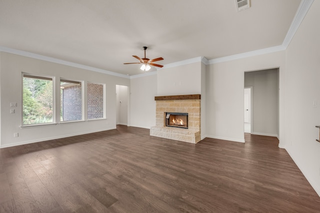 unfurnished living room featuring a stone fireplace, dark wood-type flooring, ceiling fan, and ornamental molding