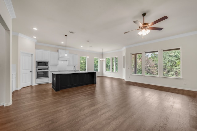 unfurnished living room with sink, ceiling fan, dark wood-type flooring, and crown molding