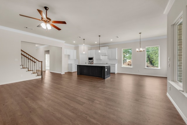 unfurnished living room featuring dark wood-type flooring, ceiling fan with notable chandelier, and ornamental molding