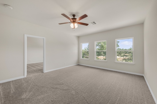 empty room featuring light carpet, a wealth of natural light, and ceiling fan