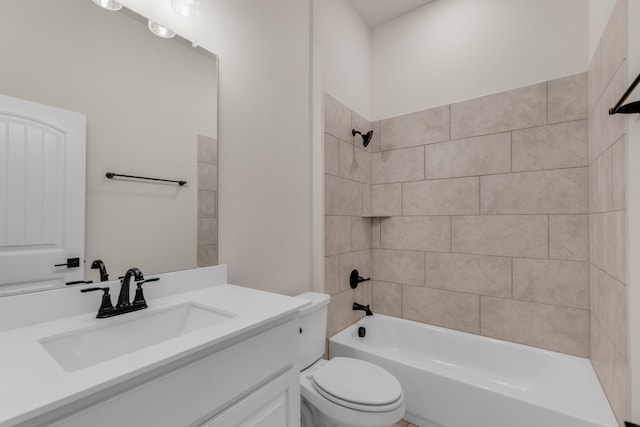 full bathroom featuring vanity, tiled shower / bath, and toilet