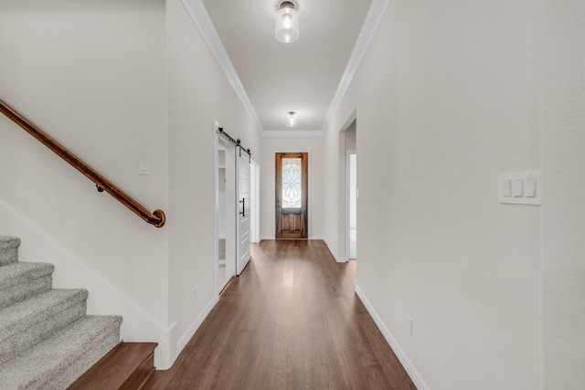 entryway featuring ornamental molding, dark hardwood / wood-style flooring, and a barn door