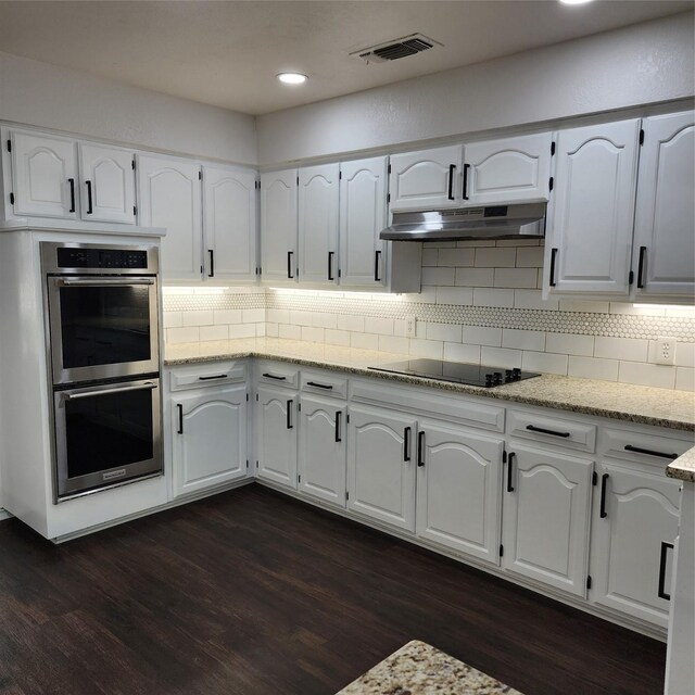 kitchen featuring black electric stovetop, dark hardwood / wood-style floors, stainless steel double oven, white cabinets, and light stone countertops