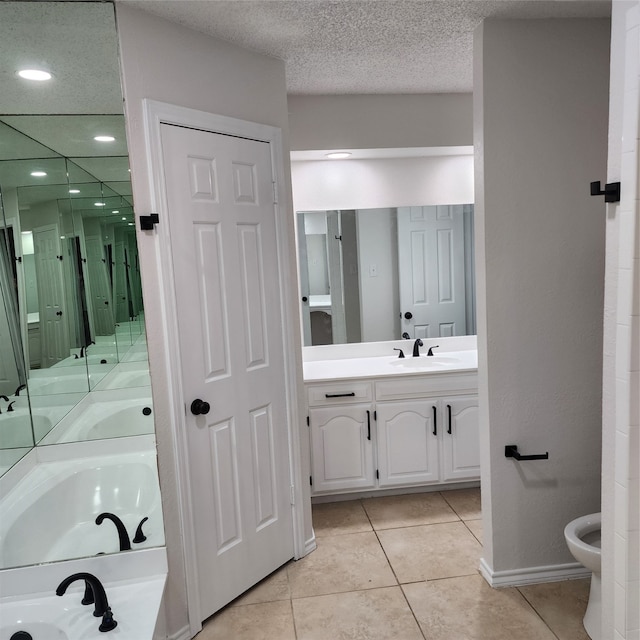 bathroom featuring a bath, a bidet, tile patterned floors, a textured ceiling, and vanity