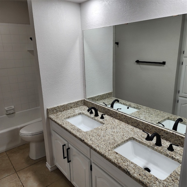 full bathroom with toilet, dual vanity, tiled shower / bath, and tile patterned floors