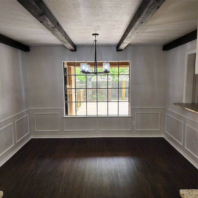 spare room featuring dark hardwood / wood-style flooring, a notable chandelier, and beamed ceiling