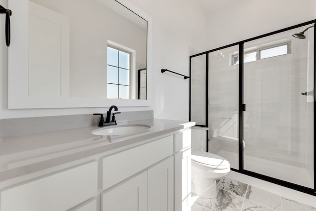 bathroom featuring vanity, toilet, and a shower with shower door