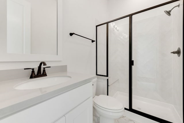 bathroom featuring vanity, toilet, and a shower with door