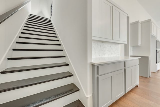 staircase with hardwood / wood-style flooring