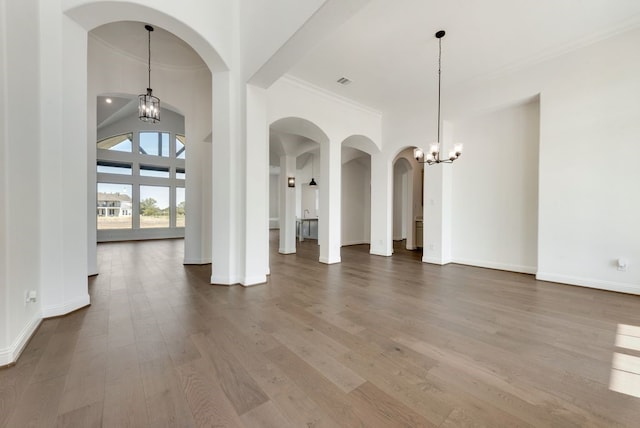 interior space with hardwood / wood-style floors, an inviting chandelier, and crown molding