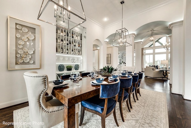 dining room with wood-type flooring, an inviting chandelier, and ornamental molding