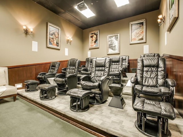 home theater room featuring a wainscoted wall, wooden walls, and carpet floors