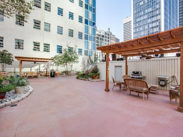 view of patio with area for grilling, ceiling fan, and a pergola
