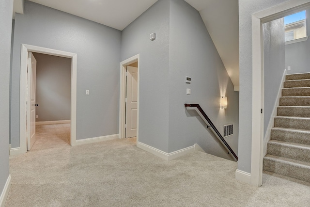 hall featuring light colored carpet and separate washer and dryer