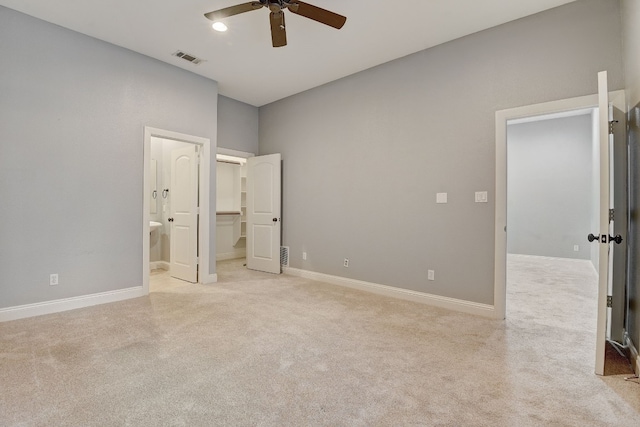 unfurnished bedroom featuring ceiling fan, light carpet, and connected bathroom